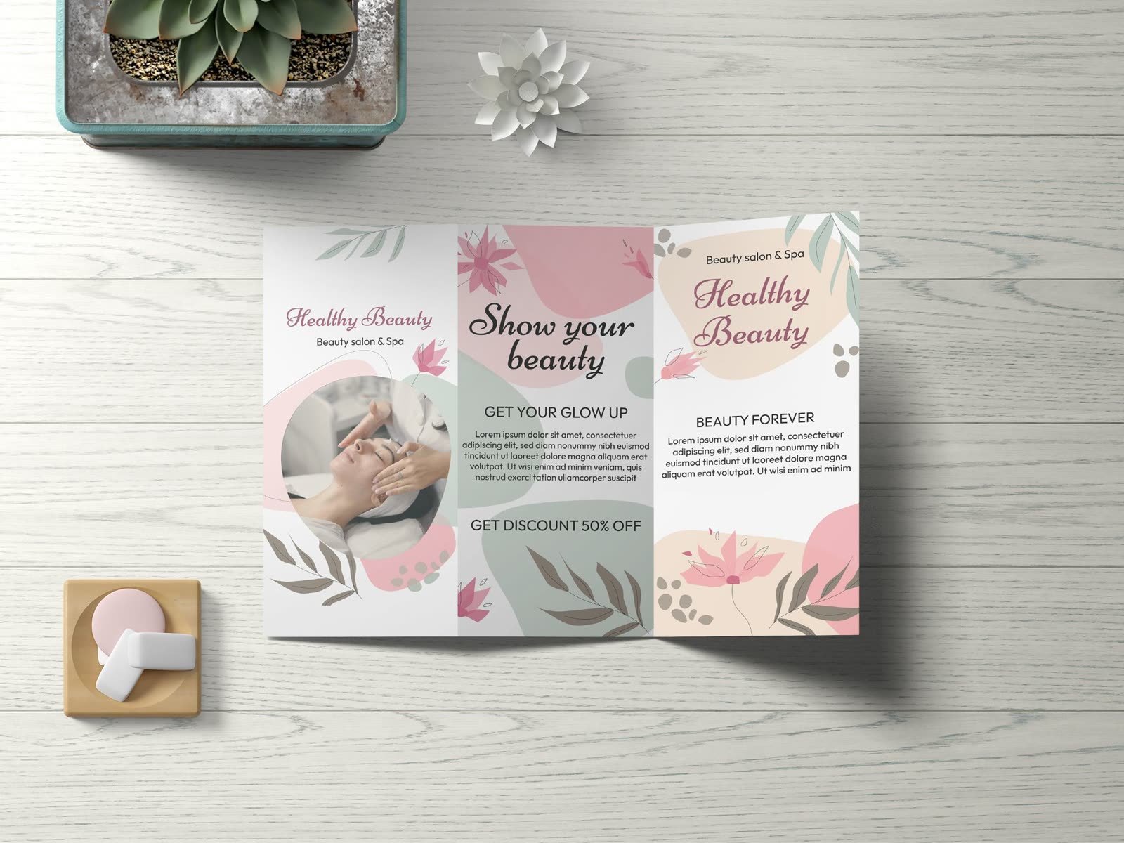 Brochure design: Healthy Beauty salon and spa trifold brochure in pink and sage on a wooden table